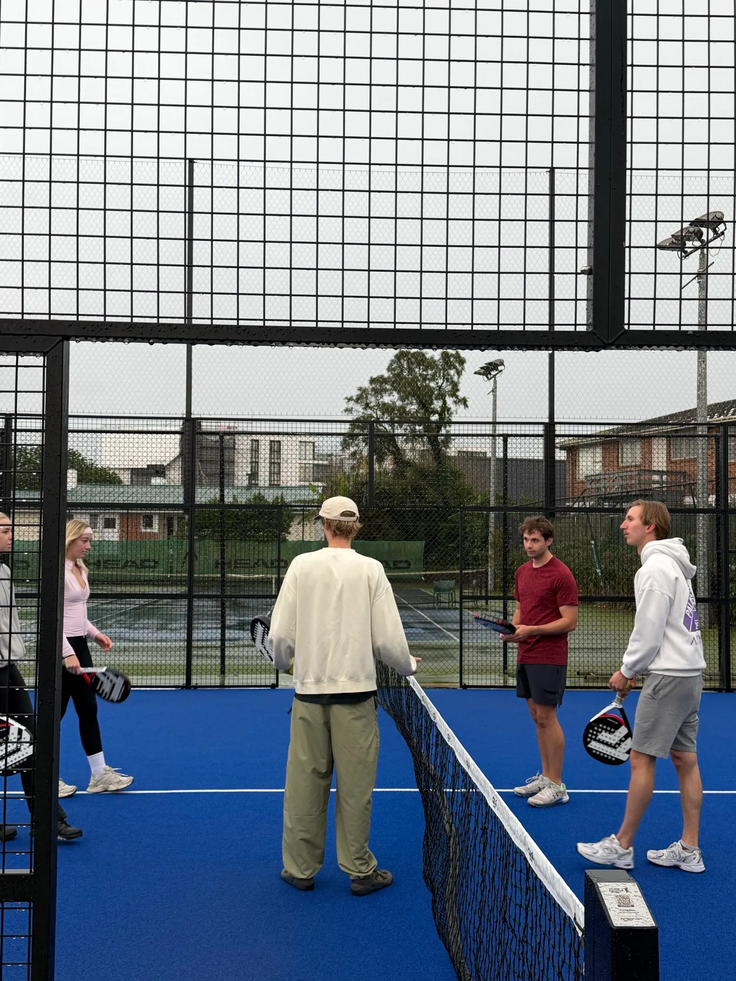 Guests with rackets on the padel court at the O-Social morning